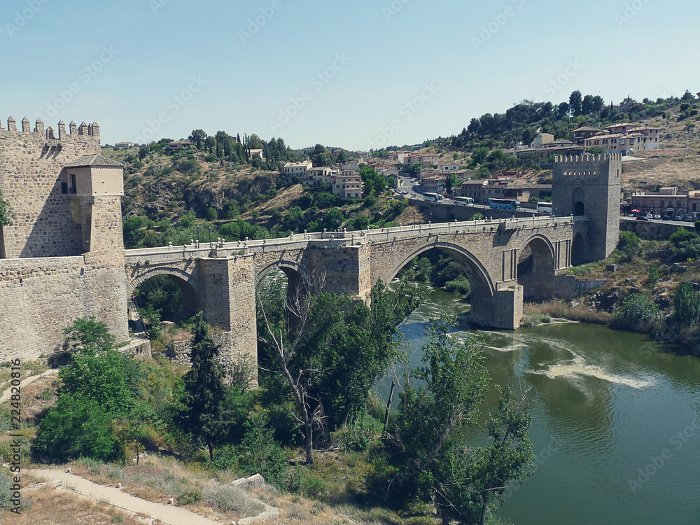 ancient bridge leading to the fortress of Toledo across a stormy river in retro style
