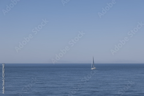 the background image of the sea and white boat and cliffs in the background