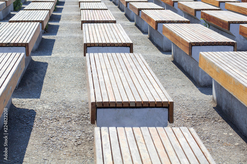 Murais de parede Empty benches wooden and concrete surface stand in several rows on the street in