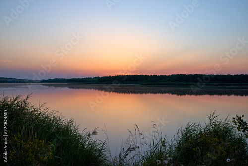 Landscape of the dawn sky and reflection in the lake. Warm colors and bright colors