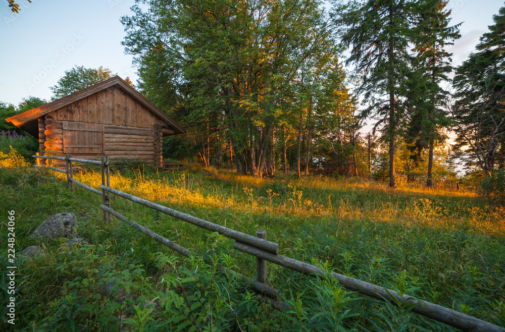House and meadow behind a wooden fence House and meadow behind a wooden fence