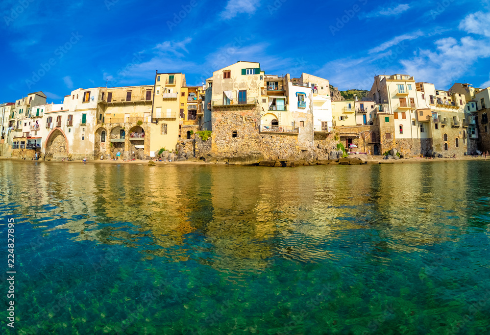 Cityscape of Cefalu village with traditional architecture reflected in water. Sicily island in Italy