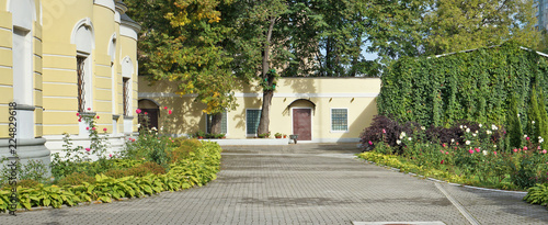 Slika na platnu The courtyard and flower garden with roses of the no name village Christian church