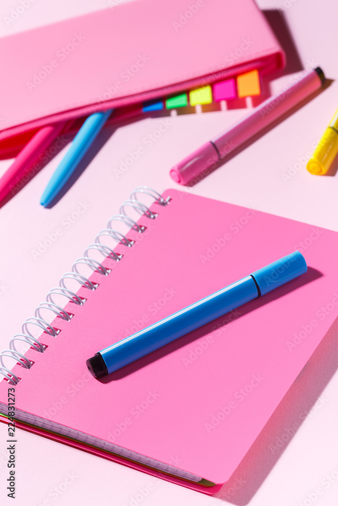Pink notebook with marker on the background of the pencil case Pink notebook with marker on the background of the pencil case
