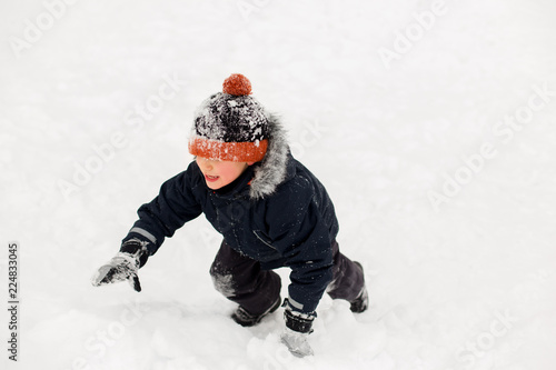 childhood, leisure and season concept - happy little boy in winter clothes outdoors © Syda Productions