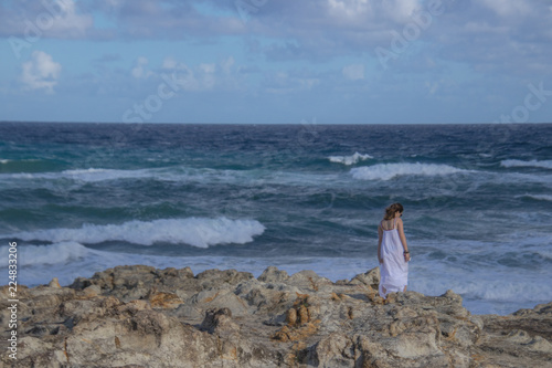 Anonymous woman standing near stormy sea