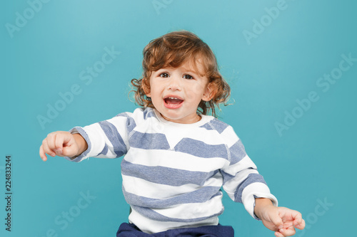 Portrait of happy joyful beautiful little boy, studio shot on blue