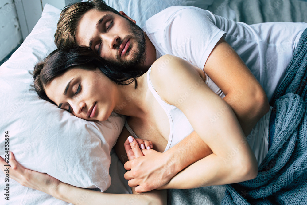 Beautiful happy young couple sleeping in bed in the morning and hugging.  Love and relationships concept Stock Photo | Adobe Stock