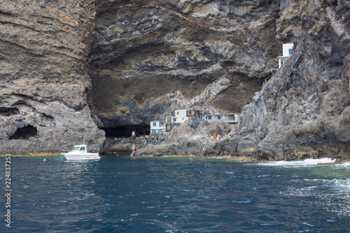 houses built on the rock by the sea with a boat