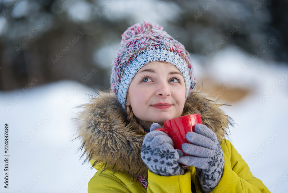 Young hipster girl relaxing in winter. Woman drinking hot tea from red cup and enjoing. Winter holidays concept. Young hipster girl relaxing in winter. Woman drinking hot tea from red cup and enjoing. Winter holidays concept.
