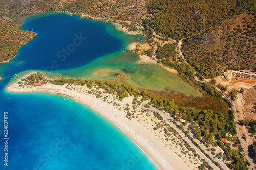 Aerial view of Blue Lagoon in Oludeniz, Turkey. Landscape with mountains, green forest, azure water, sandy beach and blue sky in bright sunny day.
