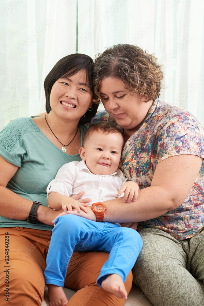 Cheerful lesbian couple with their little baby boy