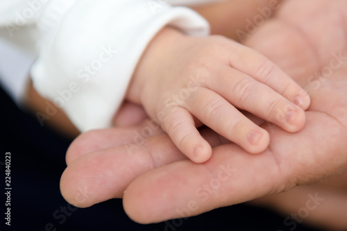 Hand of the newborn in his father's hand. The tenderness of motherhood is in the details. Procreation in childbirth and love. 