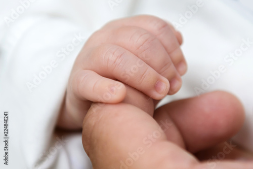 The child's fingers in his father's hand. The tenderness of motherhood is in the details. Procreation in childbirth and love. 