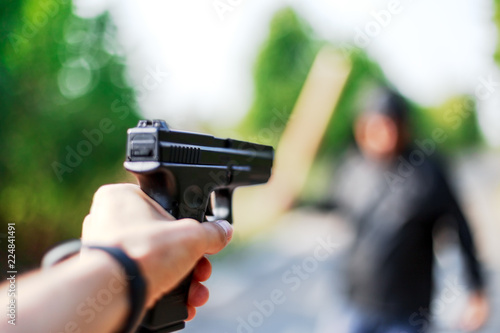 Person pointing a gun at the attacker