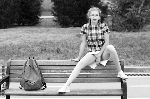cute nerd girl sitting  in provocative pose on bench