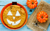 Jack-o'-lantern pumpkin pie for halloween on blue wooden background top view