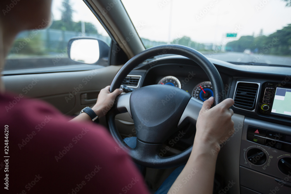 Commuting woman driving car on city road Commuting woman driving car on city road