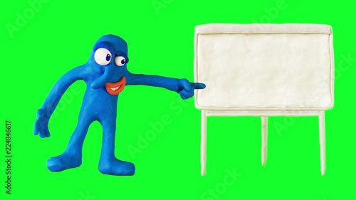 Clay Boy pointing on the white marker board. Claymation. Greenscreen
