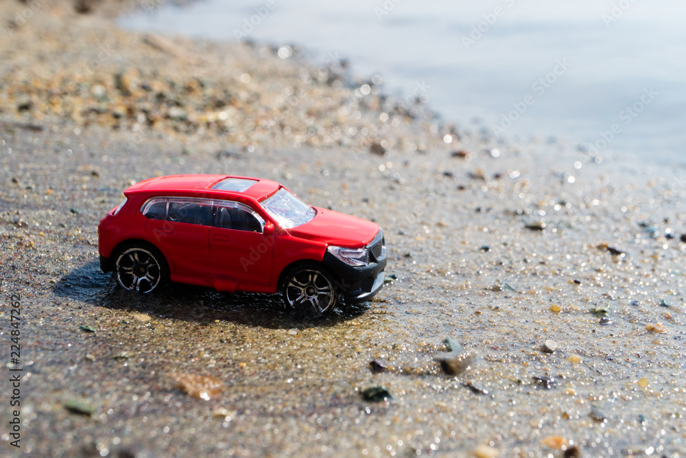 one red toy car on the beach, the beach in the summer