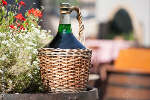 Obraz na płótnie Large Vintage Wine Bottles in wicker basket on a barrel
