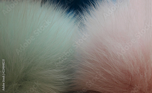 Bubon or pompon made of fur. Fluffy fur of pastel tones. Close-up, selective focus, side view, copy space. photo