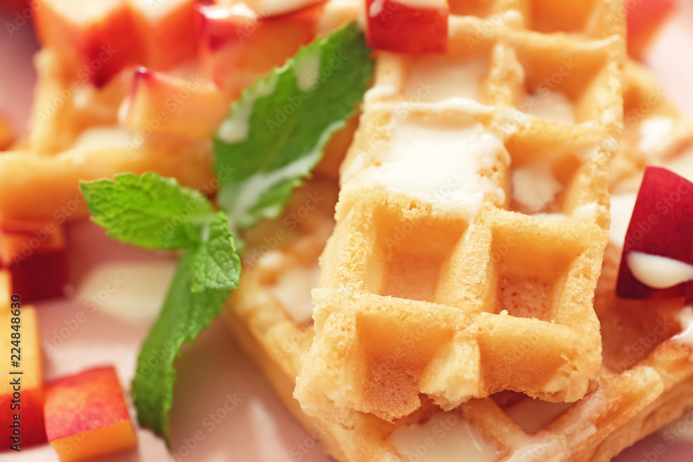 Delicious waffles with sauce and fruits, closeup