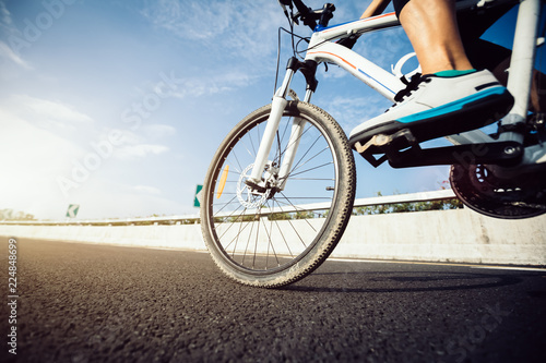 Cyclist legs riding Mountain Bike on highway