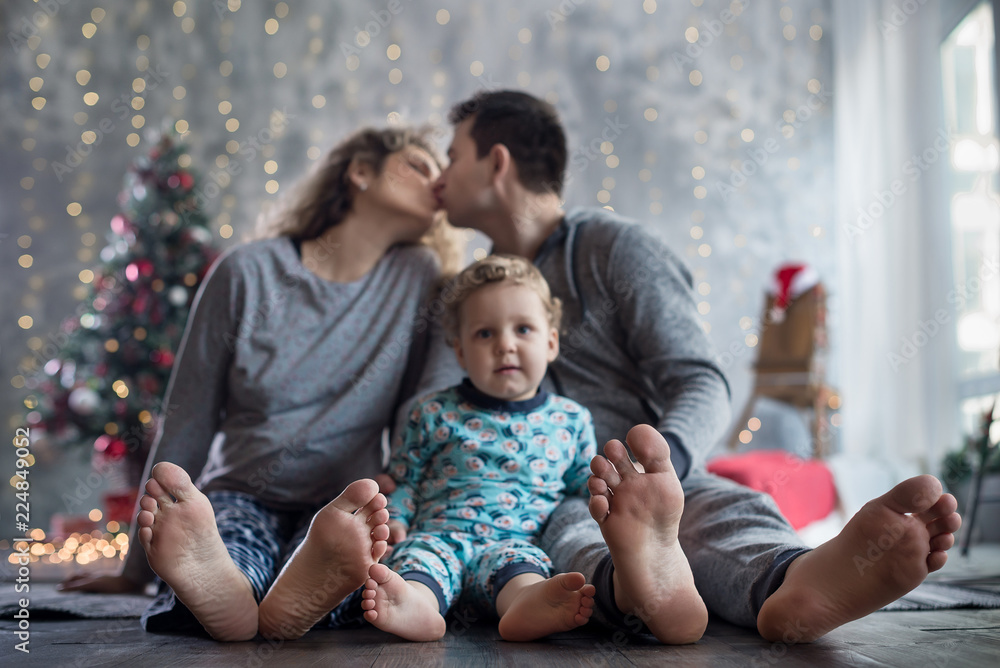 Happy pregnant family with little son at christmas decorated home near christmas tree