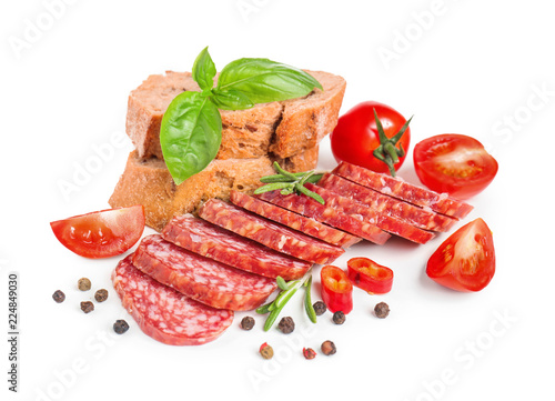 Slices of tasty smoked sausage with tomatoes and bread on white background