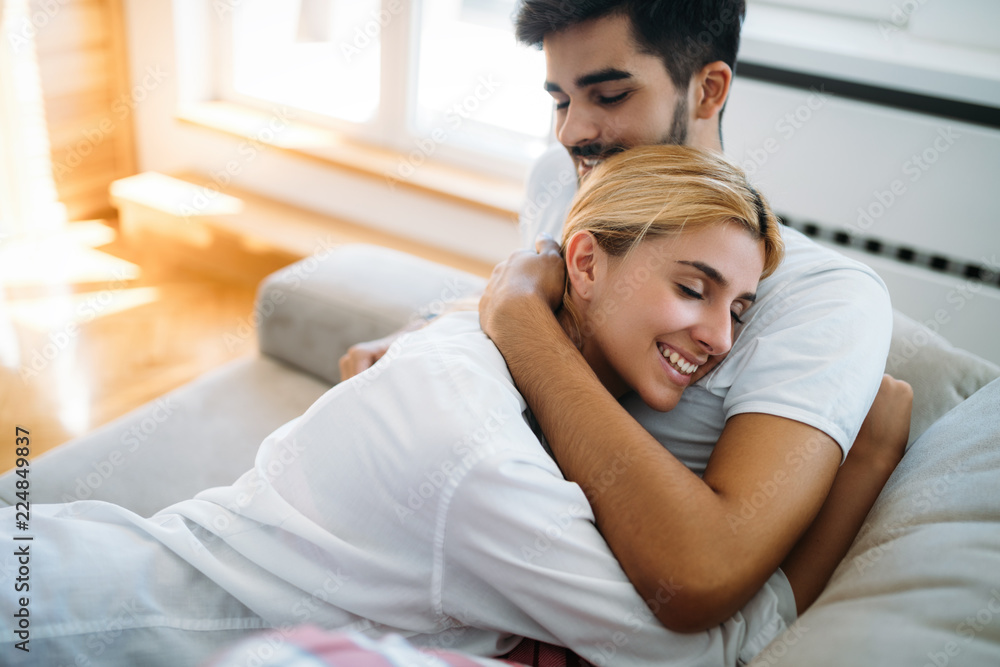 Cute couple hugging and smiling in their home Cute couple hugging and smiling in their home