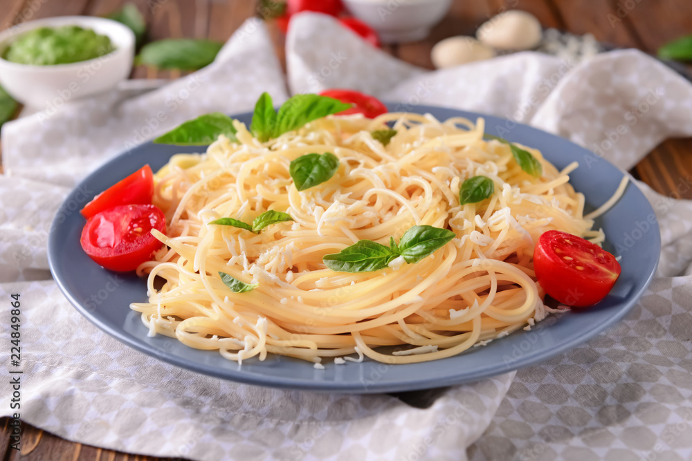 Delicious pasta with basil, cheese and tomatoes on plate