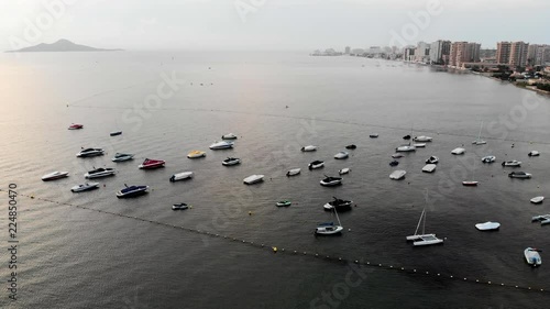 Aerial view of  boats and yachts parking at small sea La Manga del Mar Menor.  Drone shot of sail boats at the sea during dramatic moody cloudy weather.