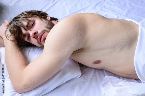 Guy nude macho lay white bedclothes. Pleasant relax concept. Man unshaven handsome guy naked torso relaxing bed. Man sleepy drowsy unshaven bearded face having rest. Let your body feel comfortable
