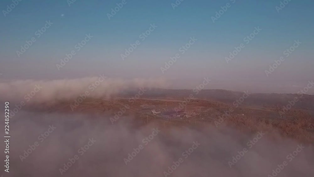 Aerial view of sunrise over fog. Fog in valley view from above. Autumn morning in mountain valley. Aerial view of sunrise over fog. Fog in valley view from above. Autumn morning in mountain valley.