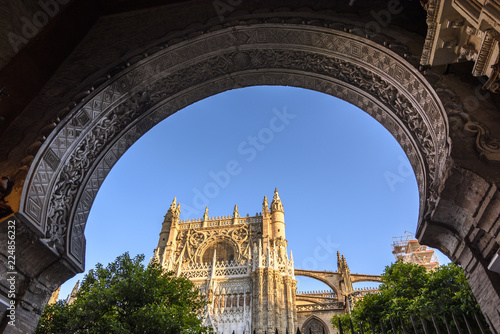 facade of the sevilla cathedral framed by the arabic arch of the door of forgiveness in Seville, Andalucia, Spain.
