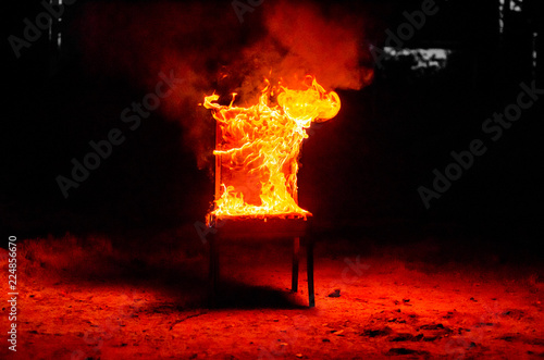 Wooden chair is on fire. Incineration of furniture. Conceptual photo, burnout