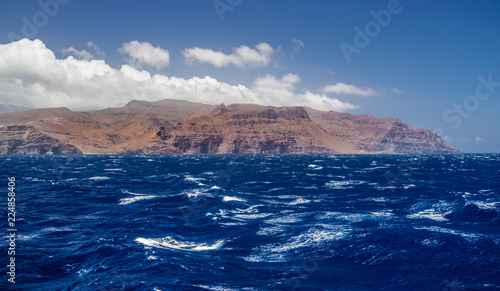 La Gomera island volcanic coastline view with waves and blue sky and clouds  Canary islands  Spain