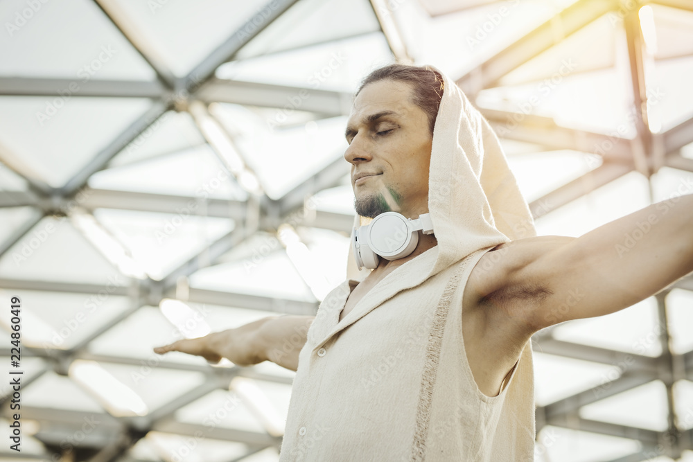 Close up of athletic man practicing yoga in modern park under the glass dome. Close up of athletic man practicing yoga in modern park under the glass dome.