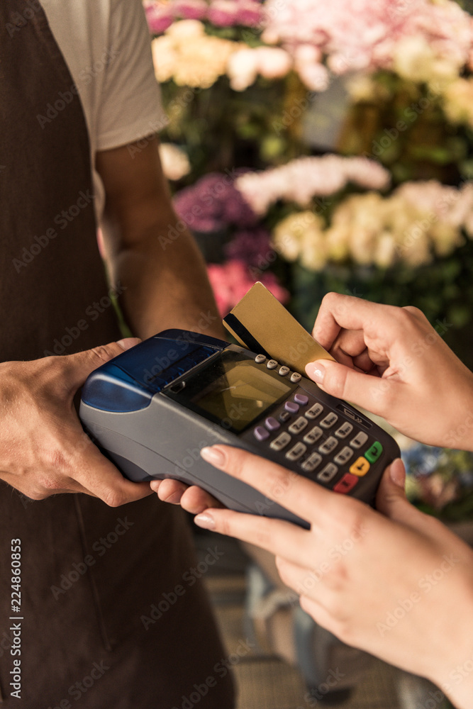 cropped image of customer paying for flowers with credit card at store cropped image of customer paying for flowers with credit card at store