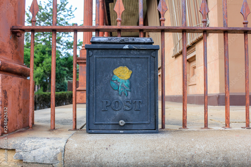 Old metal letterbox with flower emblem Old metal letterbox with flower emblem