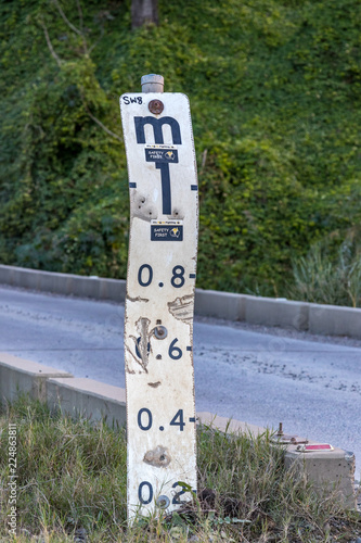 Bridge over river with flood indicator sign