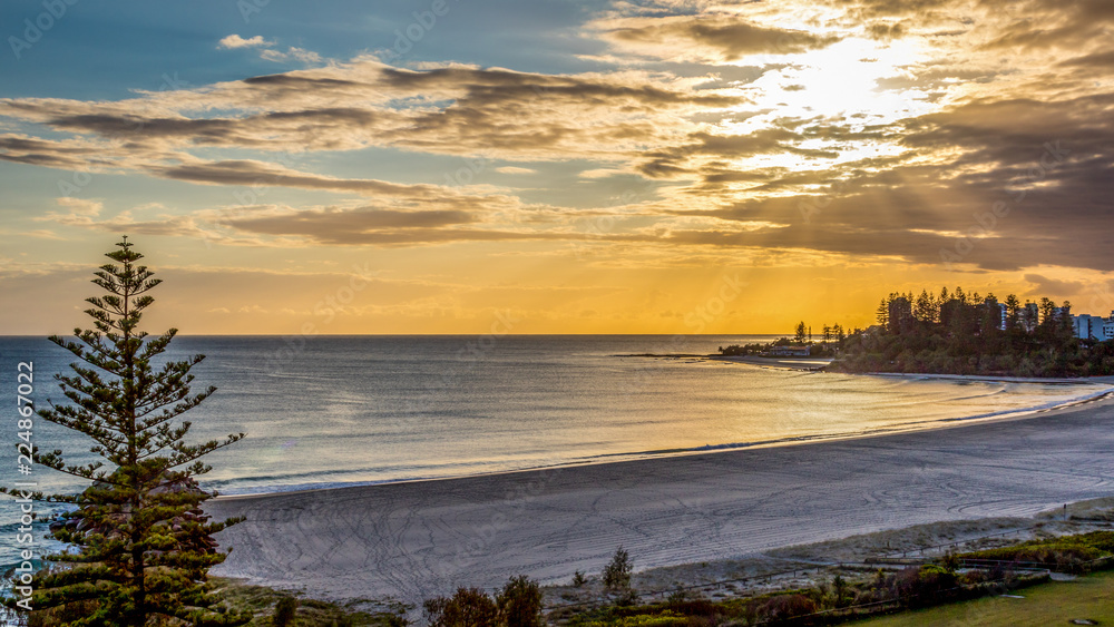 High view of cloudy sunrise over ocean and beach High view of cloudy sunrise over ocean and beach