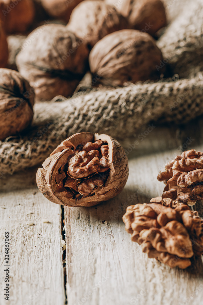 close-up view of whole and cracked walnuts and sackcloth on wooden table close-up view of whole and cracked walnuts and sackcloth on wooden table