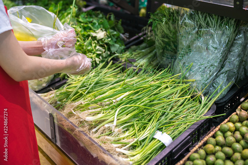 Fresh tropical vegetables on shelves in supermarket. Supermarket shelf, organic herbs on display