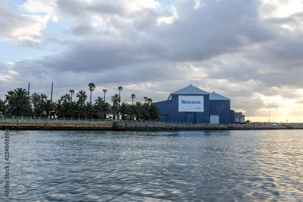 Fototapeta premium Industrial building on harbour below cloudy sky