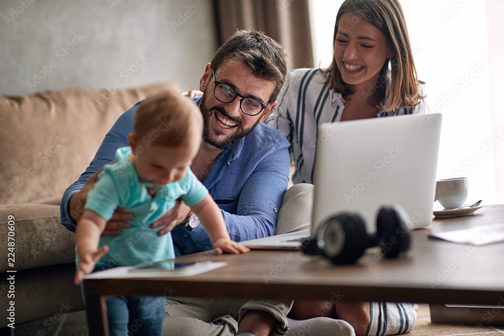 Couple with baby working from home using laptop. Couple with baby working from home using laptop.