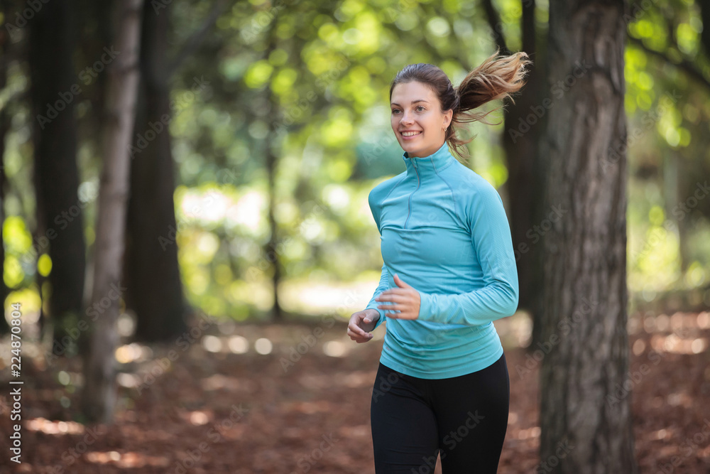A beautiful girl in sportswear is running around in the park in the fall. A beautiful girl in sportswear is running around in the park in the fall.