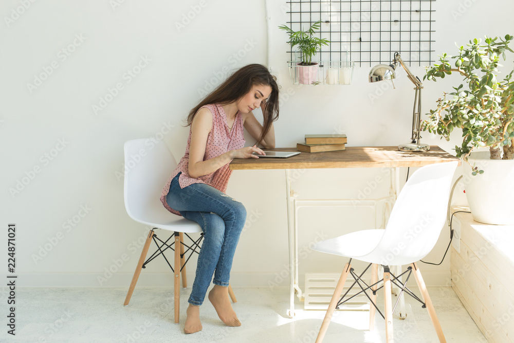 Technologies, people concept - young woman sitting on chair and watching the laptop or surfing the net Technologies, people concept - young woman sitting on chair and watching the laptop or surfing the net