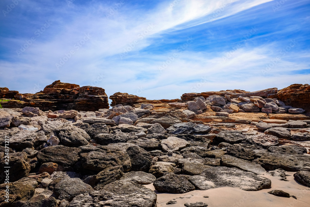 Rock formations on coast against ocean and blue sky